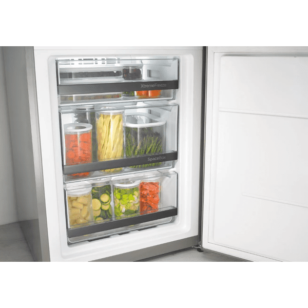 Otvorený mraziaci priestor s tromi priehľadnými zásuvkami, v zásuvkách sú uložené nádoby so zeleninou, viditeľné nápisy XtremeFreeze a SpaceBox.