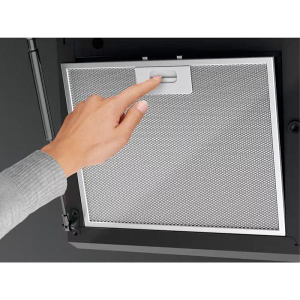 Detail ruky vyberajúcej kovový tukový filter z digestora