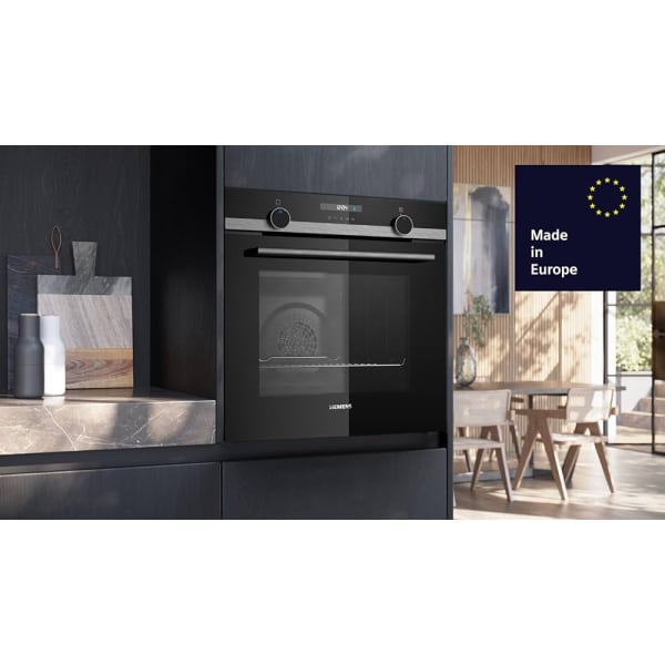 Moderná kuchyňa s integrovanou rúrou Siemens; na paneli sú ovládače a displej, v pozadí jedálenský stôl.