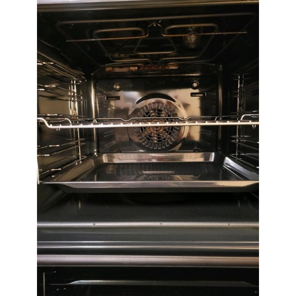 Vnútro rúry s ventilátorom na zadnej stene, dvomi mriežkami a plechom na pečenie.