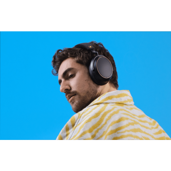 Muž so slúchadlami Sennheiser MOMENTUM 4 Wireless na hlave v štúdiovom prostredí